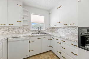 Kitchen Features White Cabinets, Dishwasher, Stove, & Refrigerator
