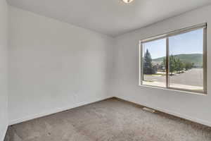 Carpeted spare room featuring baseboards and a mountain view