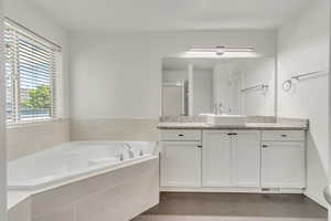 Full bath with vanity and a garden tub