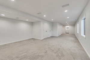 Unfurnished room with recessed lighting and light colored carpet