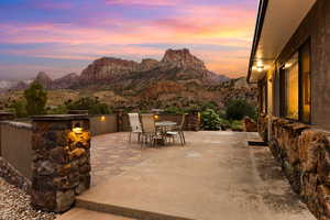 Patio terrace at dusk featuring a patio area, a mountain view, and outdoor dining area