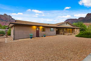 Ranch-style home featuring a mountain view, stucco siding, and a patio area