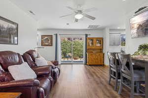 Living area with dark wood-style flooring, a ceiling fan, and recessed lighting