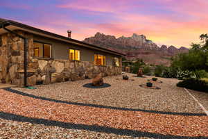 Back of house with stone siding, stucco siding, and a mountain view
