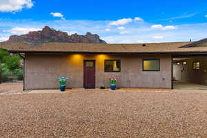 View of front facade with stucco siding, a mountain view, and a shingled roof
