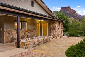 Doorway to property featuring stone siding, stucco siding, and a mountain view