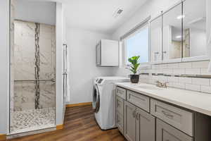 Laundry area with dark wood-style flooring and washer / clothes dryer