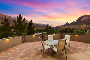 Patio terrace at dusk featuring a mountain view, a patio, and outdoor dining space