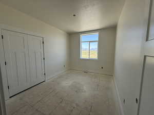 Unfurnished bedroom with a textured ceiling and a closet