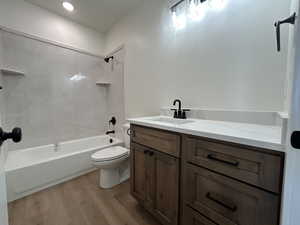 Full bath featuring shower / washtub combination, vanity, and light wood-style flooring