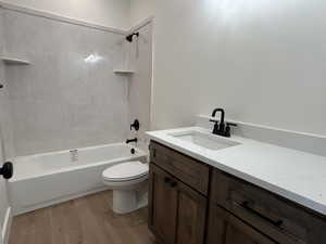 Full bathroom with bathtub / shower combination, vanity, and light wood-style flooring