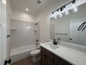 Bathroom featuring  shower combination, dark wood-style floors, vanity, and recessed lighting