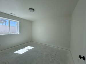 Empty room with baseboards and concrete floors