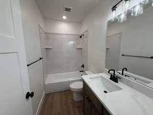 Full bathroom with light wood finished floors, vanity, and shower / washtub combination