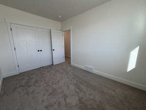 Unfurnished bedroom with carpet and a closet
