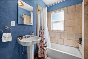 Bathroom featuring shower / bath combo with shower curtain and a sink