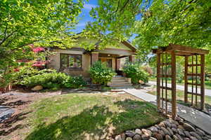 View of front of house featuring brick siding, covered porch, and a front yard