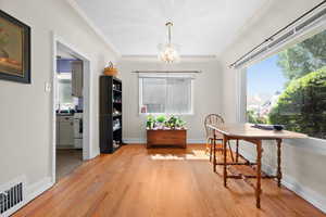 Home office featuring a chandelier and light wood-style flooring