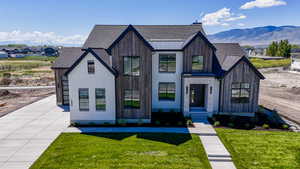 View of front of home featuring a front yard, roof with shingles, and a mountain view