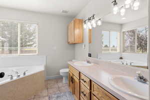 Owner's En Suite with a garden tub, double vanity, plenty of natural light, and tile patterned floors