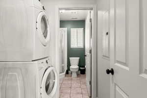 Laundry room featuring stacked washer / drying machine and light tile patterned floors