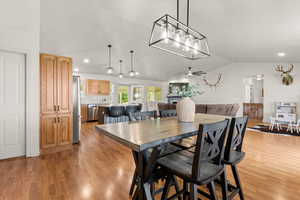 Dining space featuring lofted ceiling, light wood finished floors, ceiling fan, and recessed lighting