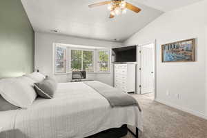 Owner's Suite featuring light colored carpet, lofted ceiling, and a ceiling fan