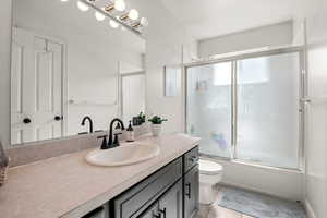 Primary bathroom with vanity, enclosed tub / shower combo, and tile patterned floors