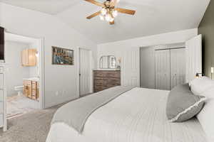 Owner's Suite with lofted ceiling, light carpet, a closet, ceiling fan, and ensuite bath