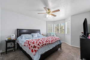 Carpeted bedroom featuring baseboards and ceiling fan