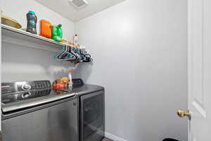 Laundry room with separate washer and dryer and baseboards