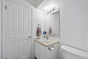 Half bathroom featuring vanity and toilet