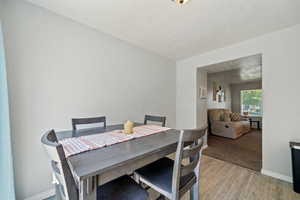 Dining space featuring light wood finished floors and a textured ceiling