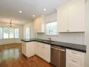 Kitchen featuring stainless steel dishwasher, dark wood-style flooring, healthy amount of natural light, a chandelier, and recessed lighting