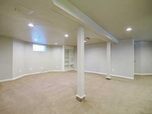 Basement with light carpet and recessed lighting