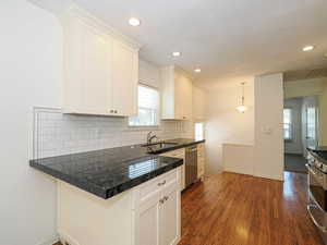 Kitchen featuring appliances with stainless steel finishes, white cabinets, tasteful backsplash, dark wood finished floors, and recessed lighting