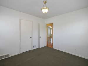 Unfurnished bedroom featuring carpet floors and baseboards
