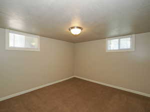 Below grade area featuring a textured ceiling and dark carpet
