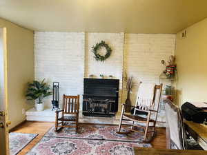 Living area featuring wood finished floors and brick wall