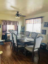 Dining room with dark wood-type flooring, plenty of natural light, and a ceiling fan