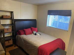 Bedroom featuring wood finished floors and a textured wall