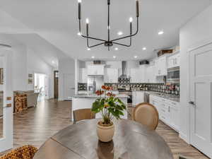 Dining area with recessed lighting, light wood-style floors, and a chandelier