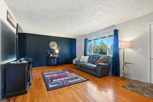 Living area featuring light wood-type flooring and a textured ceiling