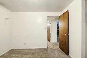 Carpeted spare room with baseboards and a smoke detector