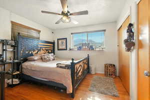Bedroom with wood finished floors, a textured ceiling, and ceiling fan