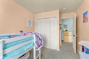 Carpeted bedroom featuring a closet and baseboards