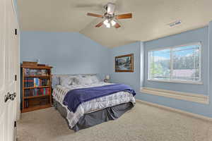 Bedroom featuring carpet floors, lofted ceiling, and ceiling fan