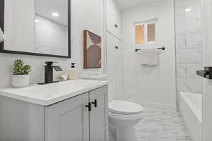 Full bath featuring marble finish floors, vanity, and shower / bathtub combination