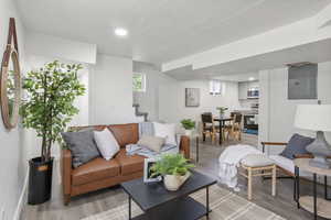 Living area with electric panel, stairway, light wood-style floors, a textured ceiling, and recessed lighting