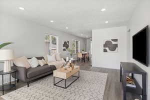 Living area featuring wood finished floors, recessed lighting, and a textured ceiling
